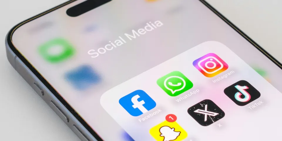 Celular con una carpeta de aplicaciones de redes sociales en la pantalla