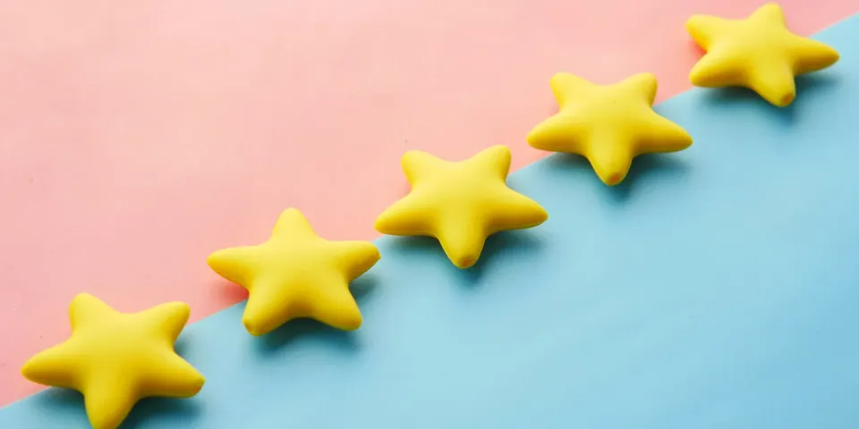 Cinco estrellas amarillas sobre un fondo rosado y azul