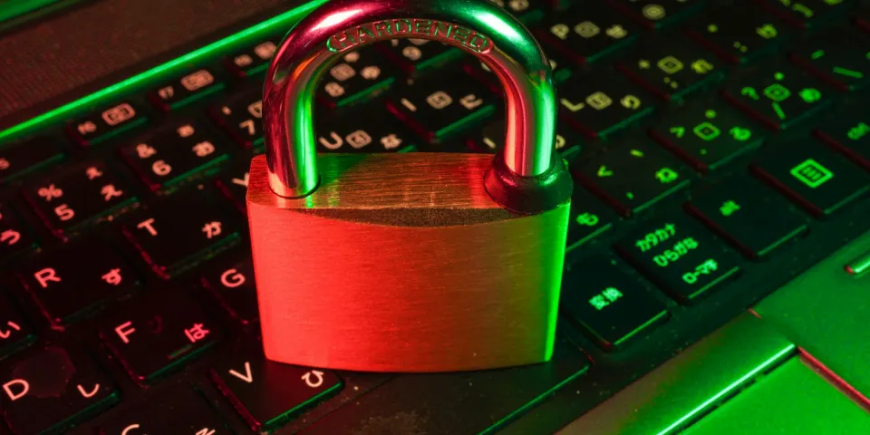 Candado rojo sobre el teclado de un computador iluminado