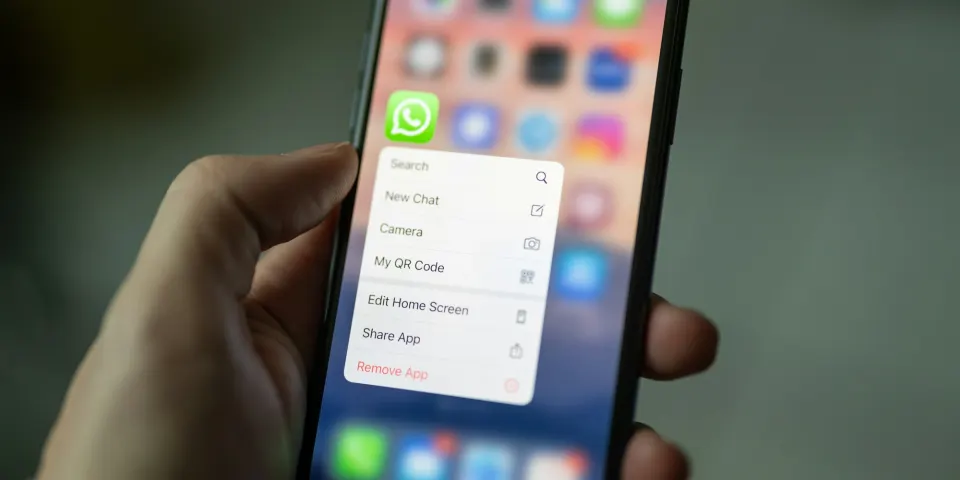 Mano sosteniendo un celular con el menú rápido de WhatsApp abierto en la pantalla