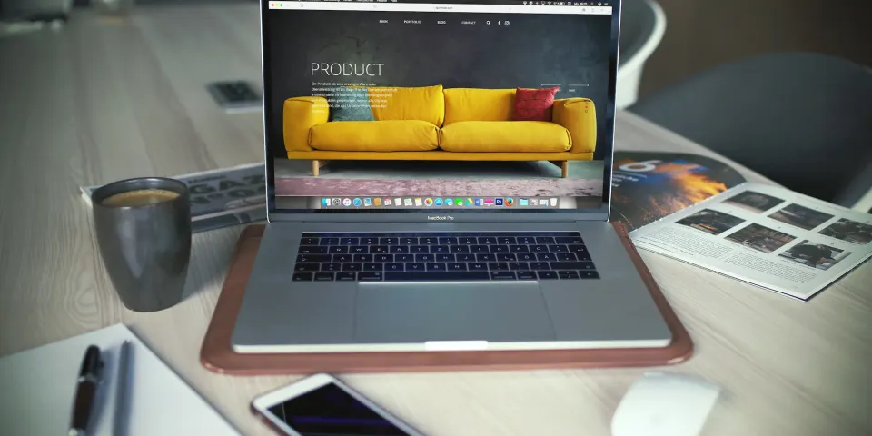 Computador portátil con una página de producto abierta sobre un escritorio de madera