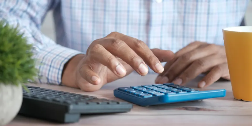 Persona revisando cotizaciones junto a un portátil