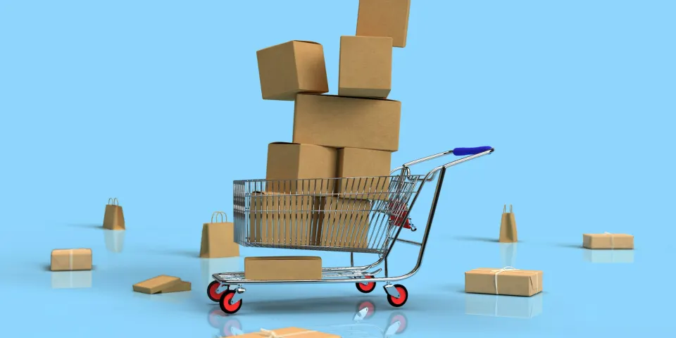 Carrito de compras lleno de cajas sobre un fondo azul