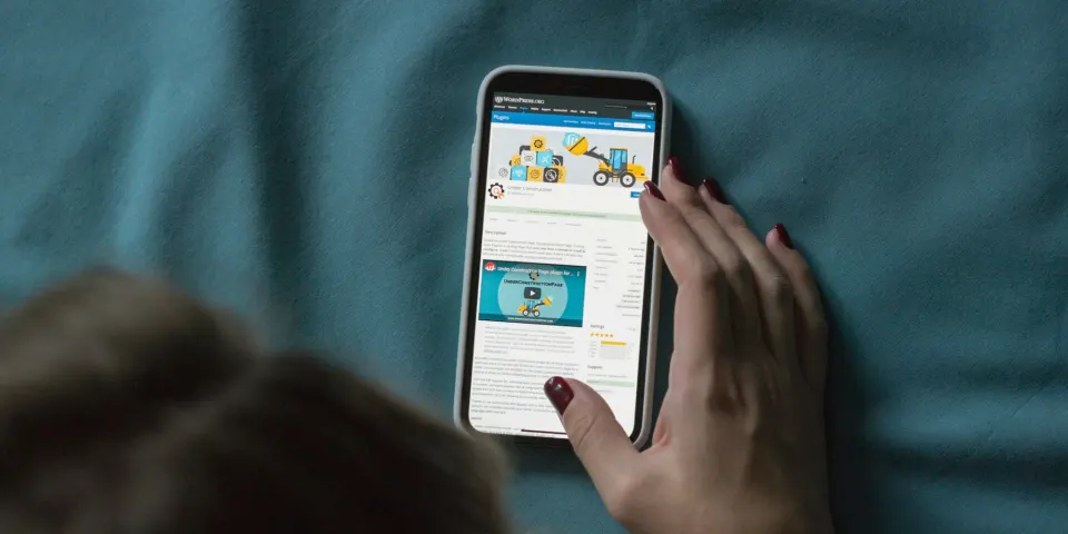 Mano sosteniendo un celular que muestra una página web