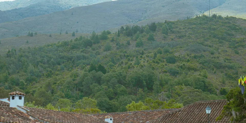 Casas blancas con techos de teja frente a montañas verdes
