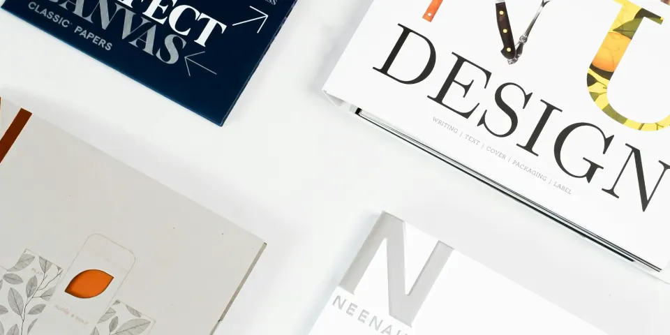 Revistas y piezas de diseño impresas sobre una mesa
