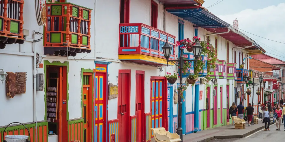 Calle de un pueblo colombiano con balcones de madera y fachadas de colores