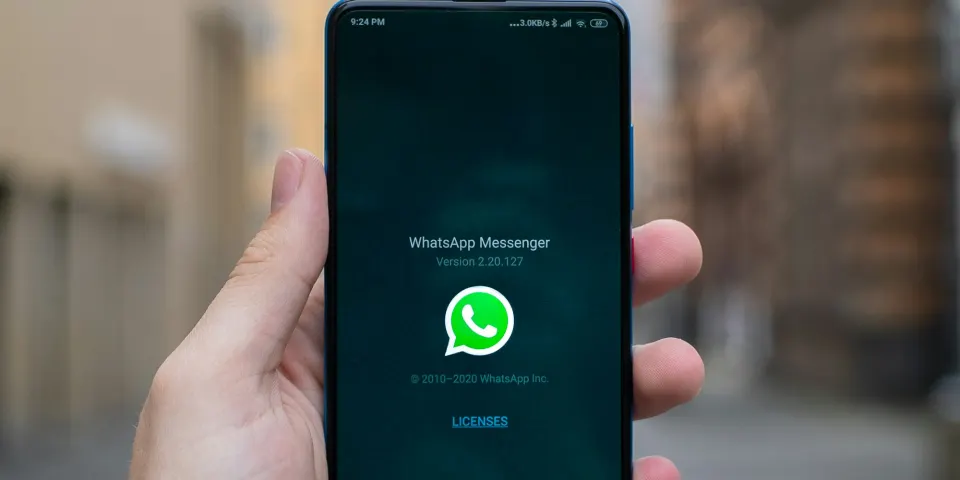 Mano sosteniendo un celular con WhatsApp abierto